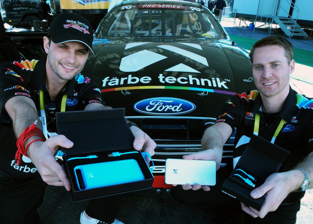 Kelowna based färbe technik entrepreneurs Shane Broesky, left and Steve Devries show off their exquisitely made and packaged mobile accessories against their NASCAR sponsored car  