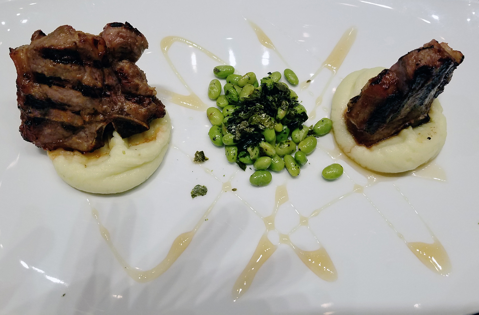 Grilled lanm chops served with soy beans and mashed potatoes 